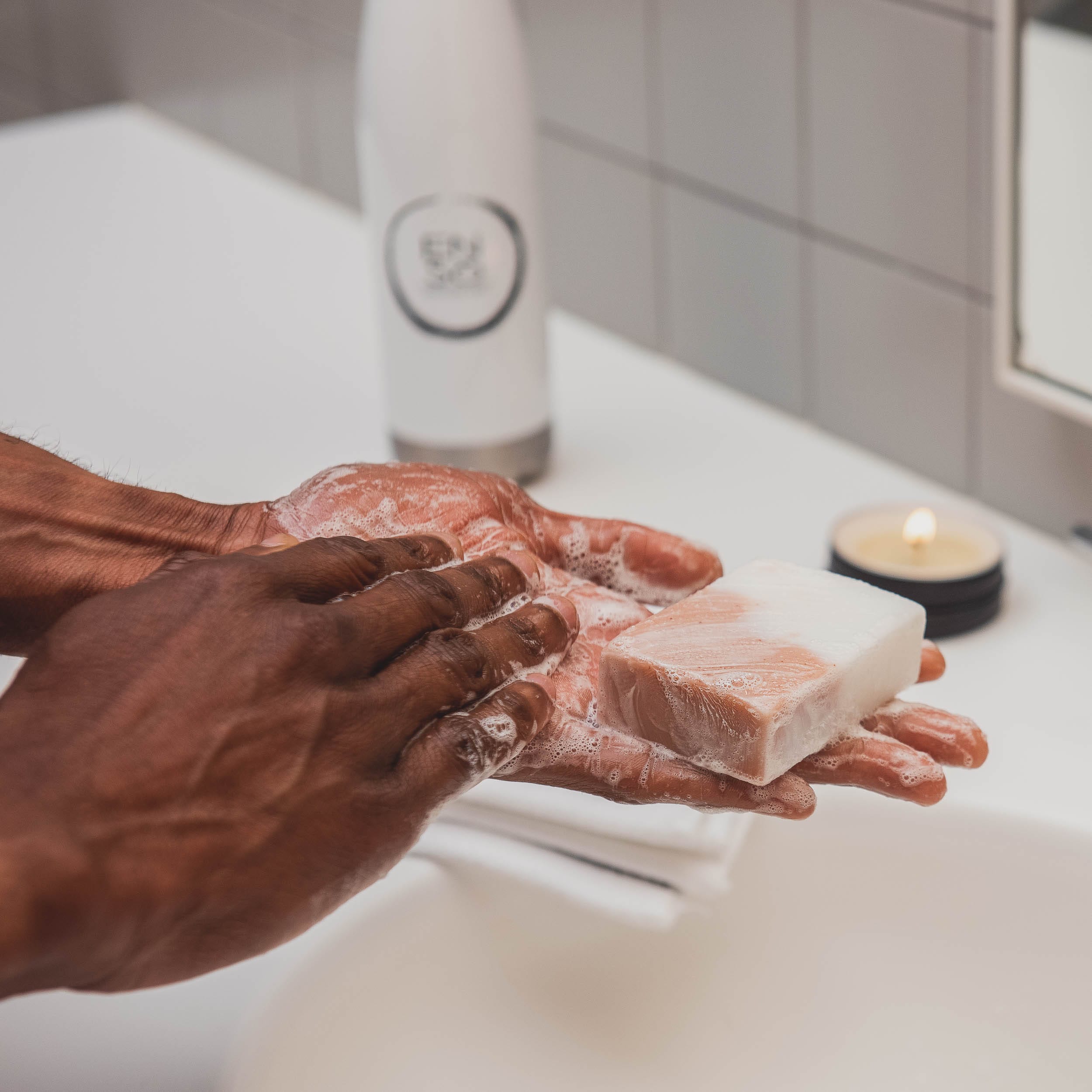 Person washing hands with coconut oil soap vegan soap in a bathroom setting